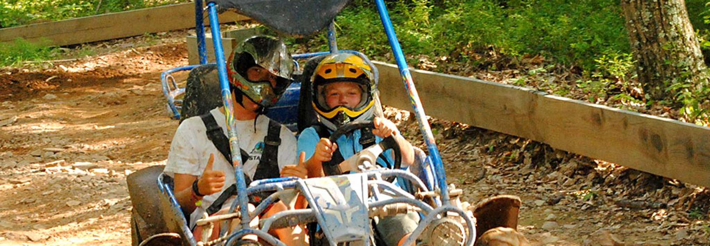 camper and staff riding go kart