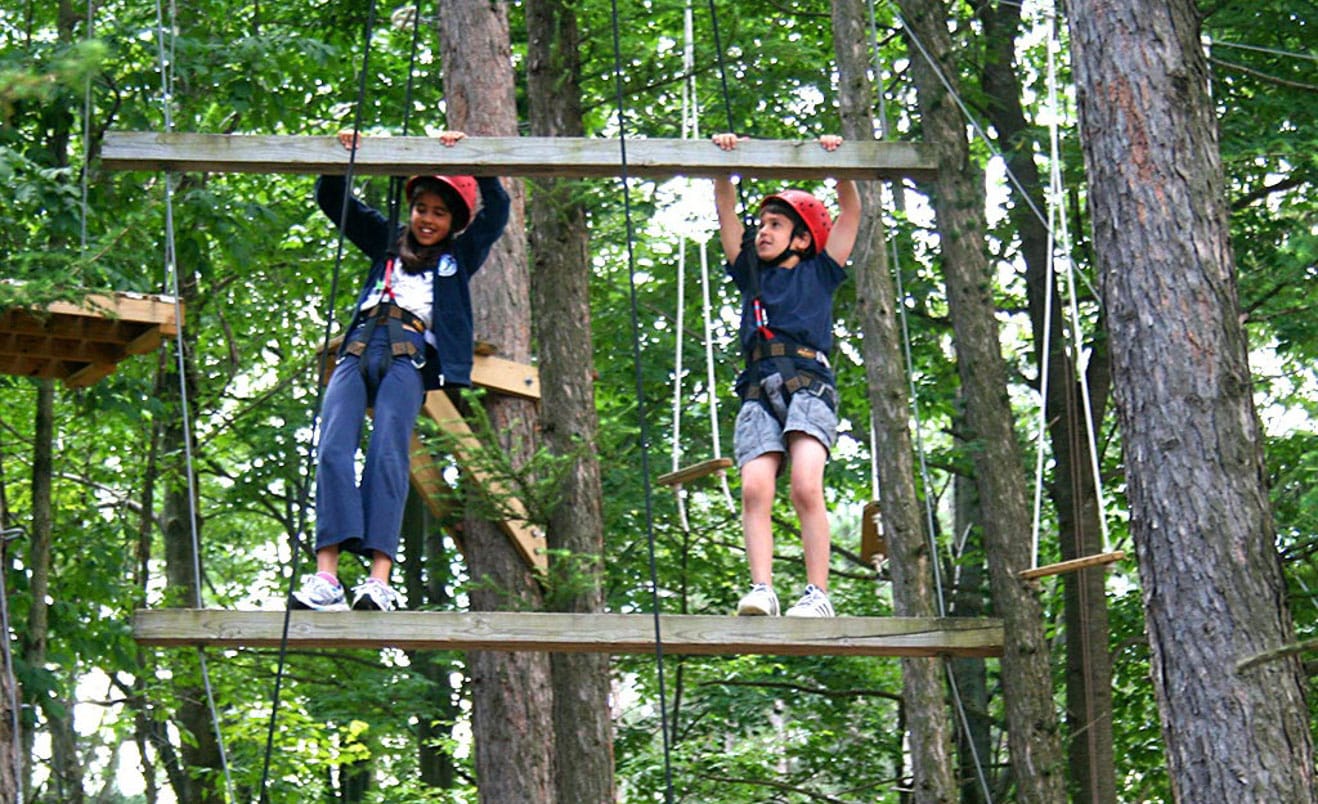 Campers on ropes course ladder during Rookie Days