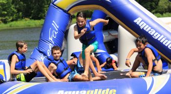 Kids choosing to play on a trampoline on the lake at Camp Lindenmere Summer Camp